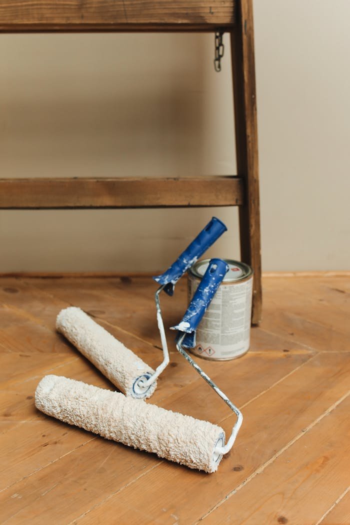 our-services-3 Paint rollers and can on a wooden floor, perfect for DIY home renovation projects.