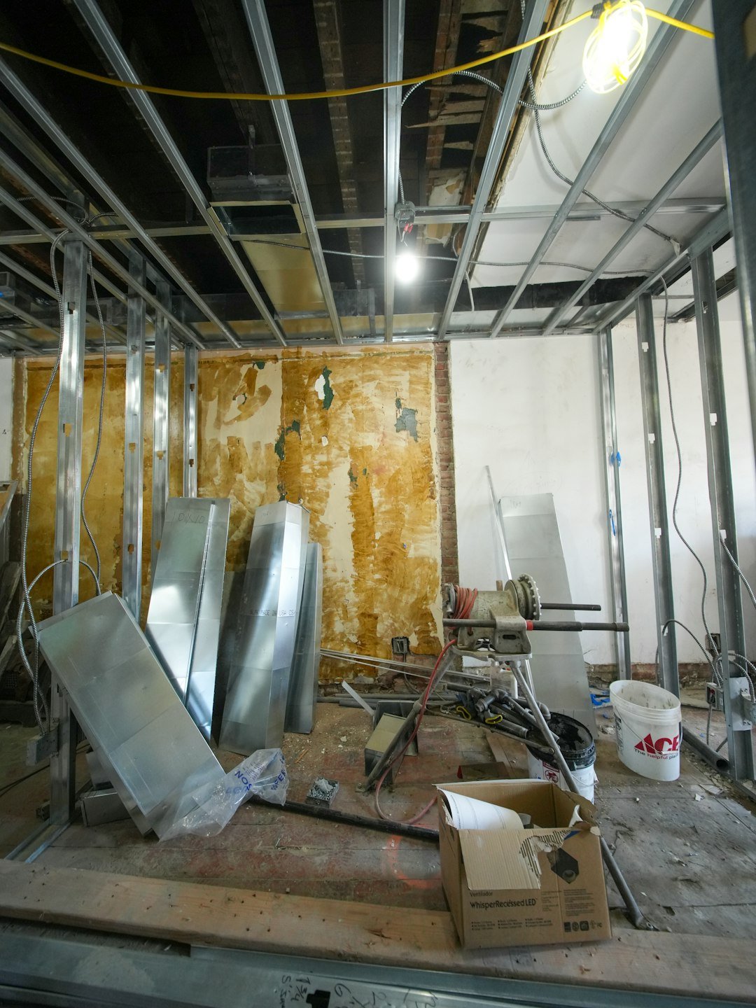 A three-story brownstone stands in mid-transformation, captured at the raw and honest “before” stage of a full interior renovation. These images document a moment that usually disappears once the walls are closed and the finishes are installed — exposed framing, stripped ceilings, rough staircases, and open corridors that reveal the building’s original structure and hidden history. Light spills in through skylights and tall windows, cutting through layers of dust and unfinished surfaces, creating a quiet contrast between decay and renewal. The space feels both industrial and intimate: narrow